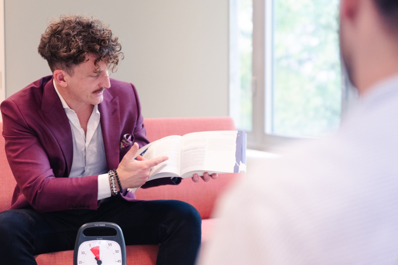 Jeremias Jurt zeigt in einem Buch im Beratungsgespräch